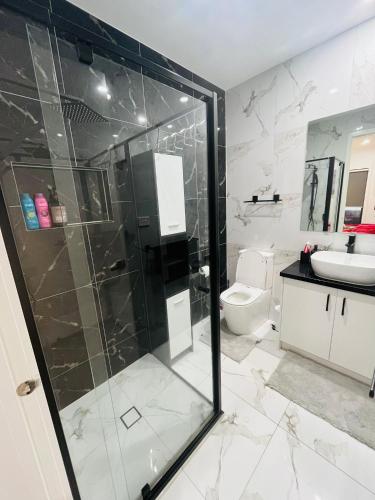 a bathroom with a glass shower and a toilet at My Home II in Tarneit