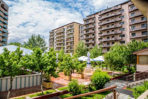 a park with trees and buildings in a city at Phoenicia Grand Hotel in Bucharest