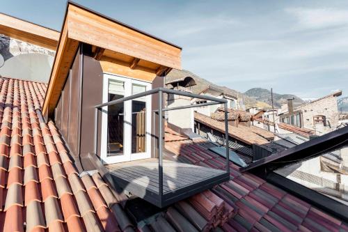 a balcony on a house with a dog on the roof at Stay COOPER l Laubenhaus in Bolzano