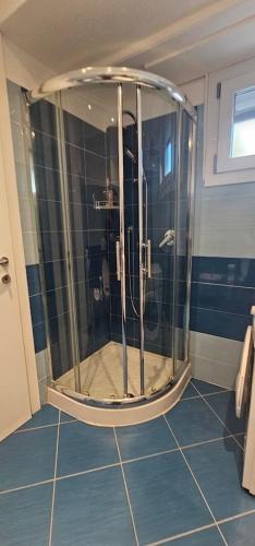 a shower in a bathroom with blue tile at Gamiga in Menton