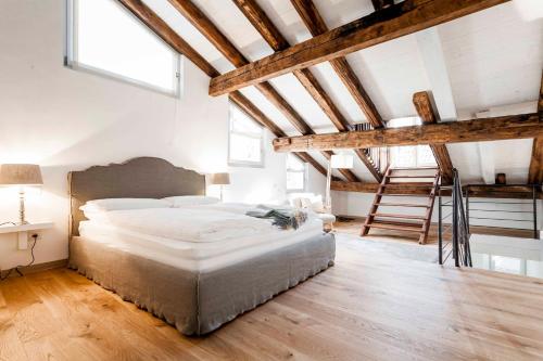a bedroom with a large bed and wooden ceilings at Stay COOPER l Laubenhaus in Bolzano