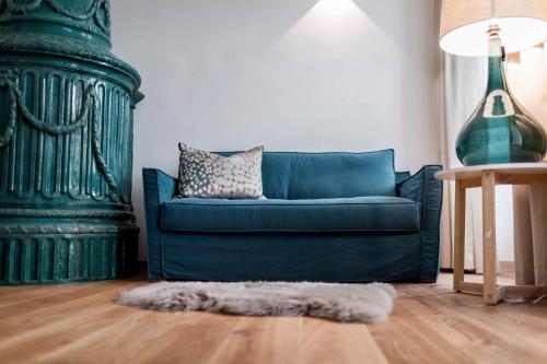 a green couch in a living room with a rug at Stay COOPER l Laubenhaus in Bolzano