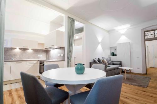 a kitchen and a living room with a table and chairs at Stay COOPER l Laubenhaus in Bolzano