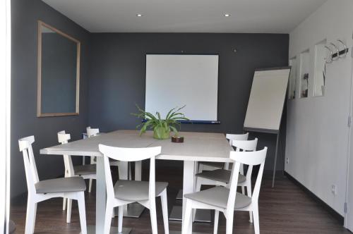 uma sala de jantar com uma mesa branca e cadeiras brancas em Fasthotel Toulouse Blagnac Aéroport em Blagnac