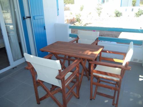 a wooden table and chairs on a balcony at Taxiarchis Studios in Áyios Yeóryios