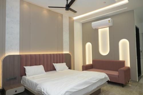 a bedroom with a bed and a bench in it at Shree Shankar Paradise in Pharod