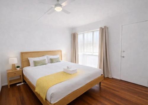 a bedroom with a large white bed with a window at 2bedrm unit next to southbank in Brisbane