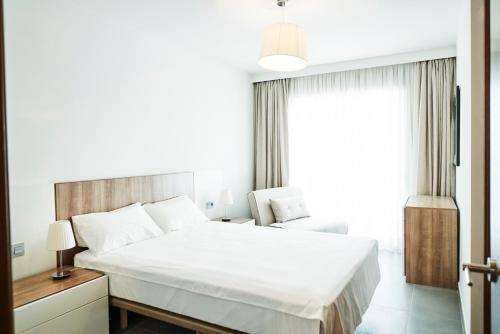 エル・メダノにあるLuxury Apartment Las Terrazasのベッドルーム(大きな白いベッド1台、窓付)