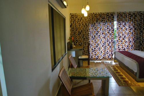 a bedroom with a bed and a table and a window at Sceva's Garden Home in Munnar