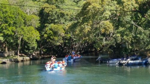 a group of people in boats on a river at Apartamentos Nuevo Amanecer in Río San Juan