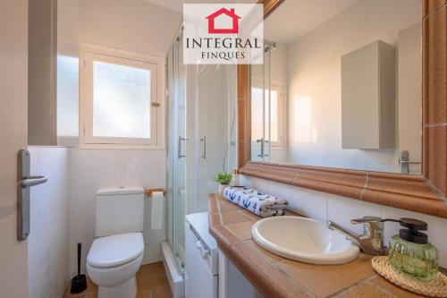 a bathroom with a sink and a toilet and a mirror at El Secret de la Fosca in Palamós