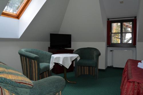 a room with chairs and a table and a tv at Willa Victor in Jastrzębia Góra