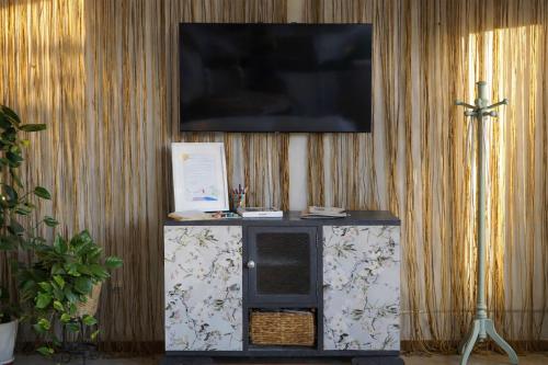 a tv on a wall with a stand with a television on it at Apartamento Atalantar in Villanueva de la Vera