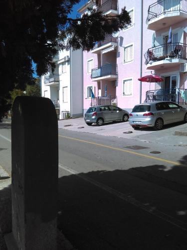 two cars parked on a street in front of buildings at Apartment Sunce in Crikvenica