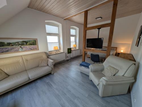a living room with two couches and a tv at Alte Stadthauswohnung mit Flair in Celle