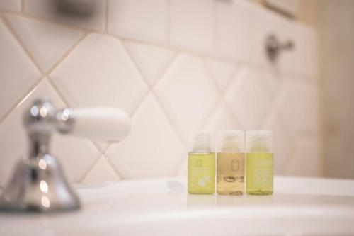 two glass jars on a bathroom counter next to a sink at Appartamento San Giovanni - centro storico di Parma in Parma
