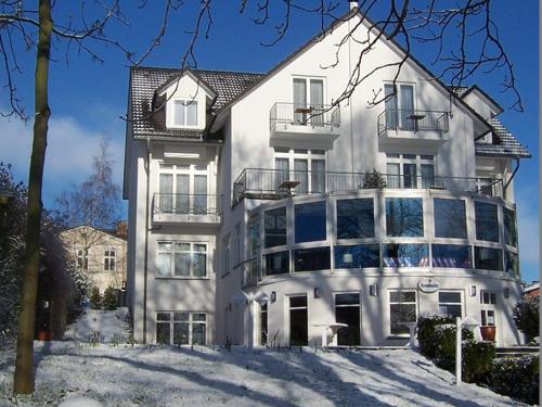 a large white building with snow in front of it at Hotel Lauterbach Auf Rügen in Lauterbach