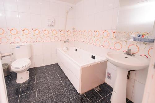 a bathroom with a sink and a tub and a toilet at Beethoven Express Hotel in Zhongli