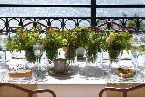 a table with flowers in glass vases on it at Avra Private Suites in Lassi