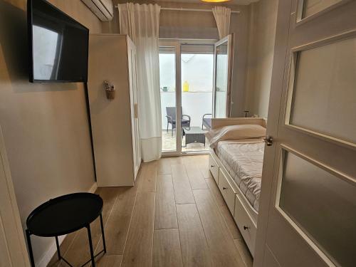a small room with a bed and a door with a window at CitySun in Málaga