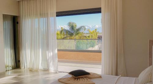 a bedroom with a bed and a large window at Villa Kaima Marrakech jacuzzi chauffé in Marrakesh