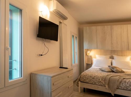 a bedroom with a bed with a television on the wall at Il Rifugio delle Valli in Comacchio