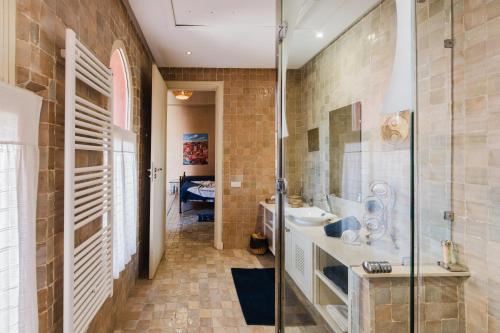 a bathroom with a glass shower and a sink at Dar Kamango - Marrakech Peaceful Retreat in Marrakesh