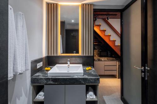 a bathroom with a sink and a staircase at The New Moon Umalas in Seminyak