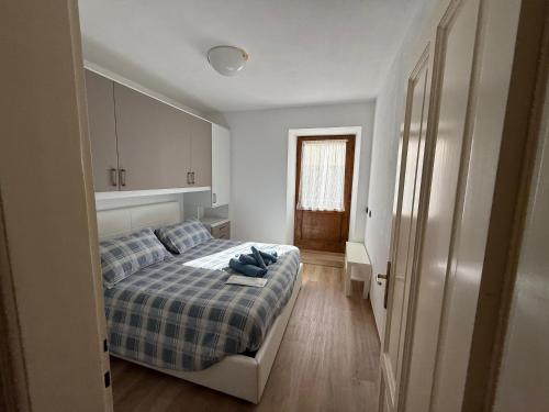 a bedroom with a bed with a blue plaid blanket at Appartamento Moena in Moena