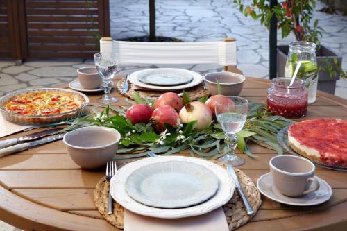 a wooden table with plates of food on it at Avra Private Suites in Lassi