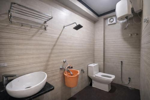 a bathroom with a white toilet and a sink at The Nest Kashi in Varanasi