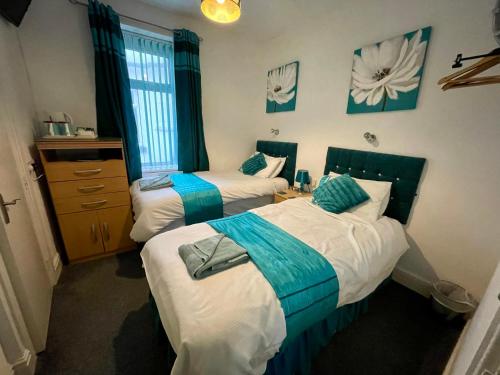 a bedroom with two beds with blue and white at Beeches Hotel in Blackpool