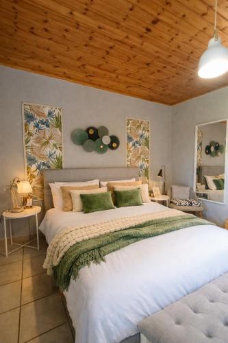 a bedroom with a large white bed and a wooden ceiling at Nafplio Cottage-Grandma's Yard in Asíni