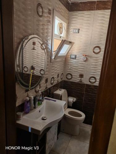 a bathroom with a sink and a toilet and a mirror at Loay Villa Stella Helipolis in Madīnat aţ Ţalāʼi‘