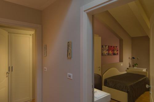 a small room with a bed and a mirror at Hotel Arnolfo & Aqua Laetitia Spa & Beauty in Montecatini Terme