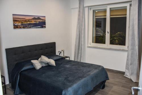 a bedroom with a bed and a window at House Nonno Viky in Volla
