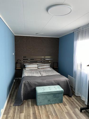 a bedroom with a large bed with a blue wall at Vatnestrøm in Iveland