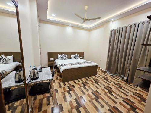 a bedroom with two beds and a ceiling fan at Crestview Inn in Lucknow