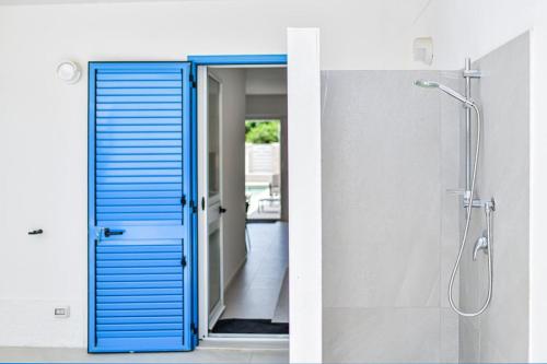a bathroom with a blue door and a shower at Villa Almaris in Marina di Ragusa