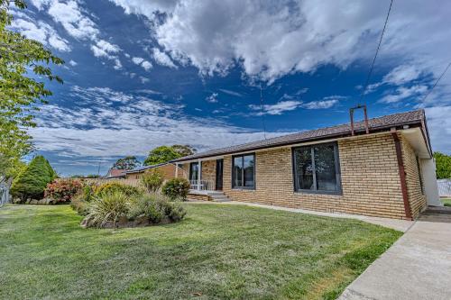 a brick house with a lawn in front of it at Villa Oberon in Oberon