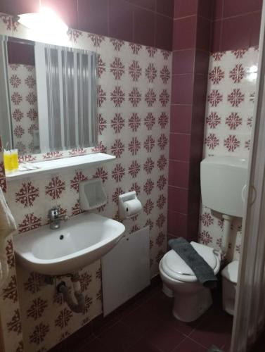 a bathroom with a white sink and a toilet at Filoxenia Marias in Loutra Ipatis