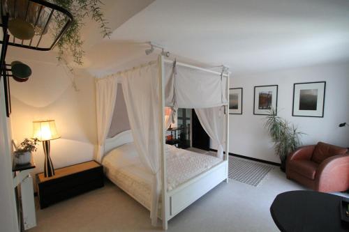 a bedroom with a canopy bed and a couch at Les chambres noires in Mélisey