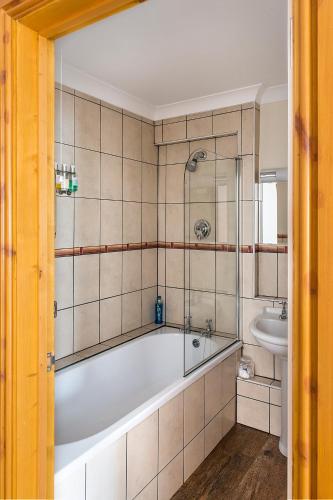 a bathroom with a tub and a sink at Spanhoe Lodge in Harringworth