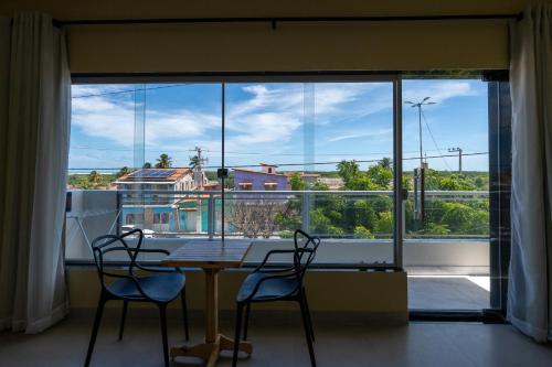 a table and two chairs in front of a large window at Suítes Oásis in Macau