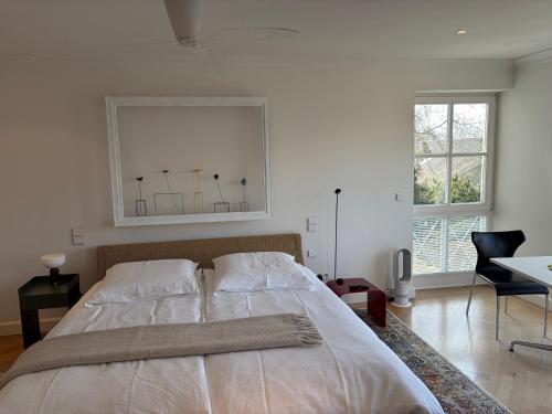 a bedroom with a large bed with a picture on the wall at Herrenhaus - Starnberger See - Ammerland in Münsing