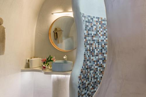 a bathroom with a mirror and a blue sink at Elite Luxury Suites in Oia