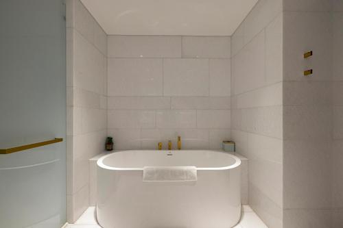 a white bath tub in a white bathroom at FIVE Palm Luxury 1BR Apartment with Stunning Views in Dubai