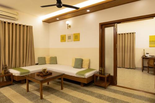 a bedroom with a bed and a table at Hanu Reddy Residences, Poes Garden - Boutique Urban Retreat in Chennai