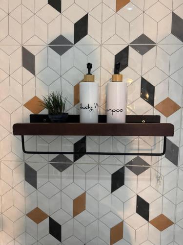 a shelf with two candles on a tiled wall at Primmy house kohtao in Ko Tao