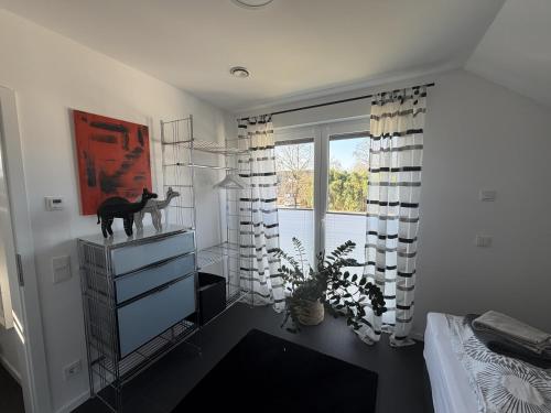 a bedroom with a cat statue on a dresser in front of a window at Moderne Ferienwohnung über 2 Etagen in Bissendorf